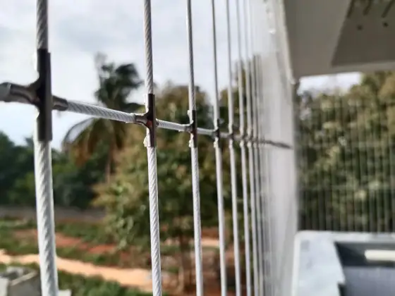 Slim cable grill keeping a balcony view clear in Adyar, Chennai (close-up view)